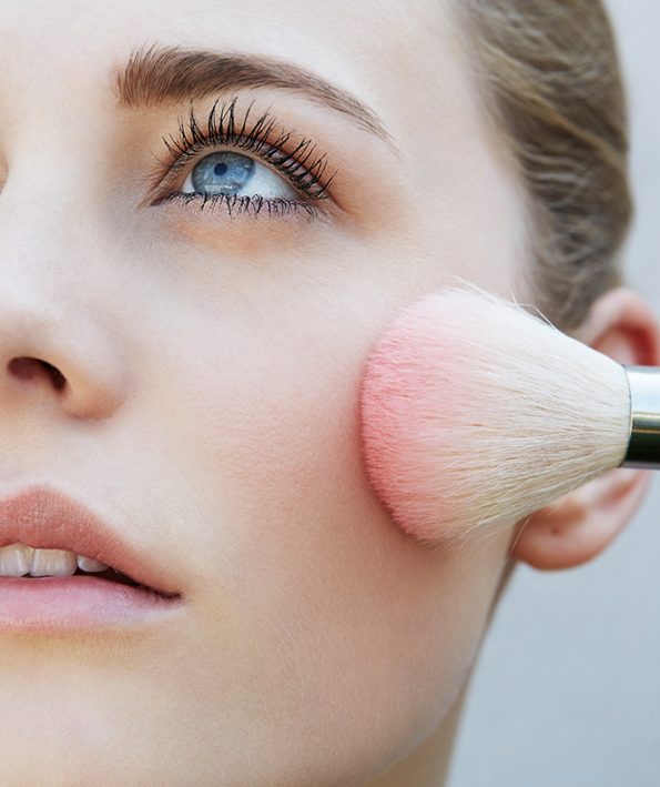 Studio shot of female model and pink blusher brush آموزش استفاده از رژ گونه متناسب با فرم صورت