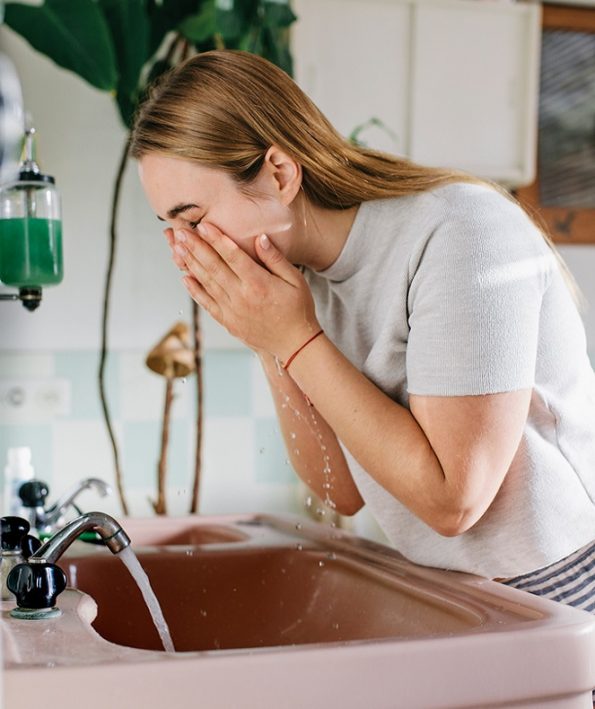 Woman in bathroom washing face چگونه از سالیسیلیک اسید استفاده کنید